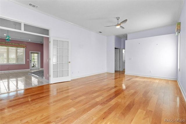 spare room featuring hardwood / wood-style floors, ceiling fan, and crown molding