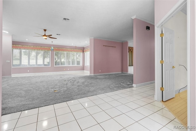 carpeted spare room featuring a wealth of natural light, ceiling fan, and ornamental molding