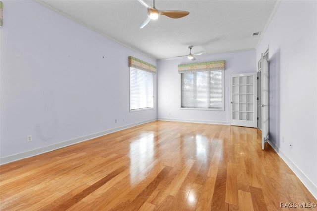 spare room featuring light wood-type flooring, ceiling fan, and ornamental molding