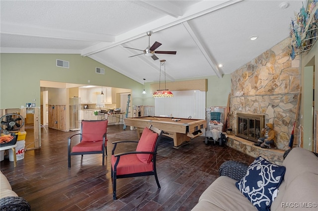 living room with beamed ceiling, dark hardwood / wood-style flooring, a stone fireplace, and billiards