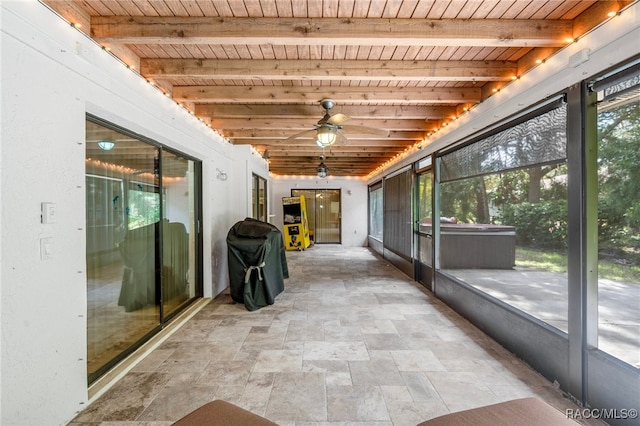 unfurnished sunroom with beam ceiling, ceiling fan, and wooden ceiling