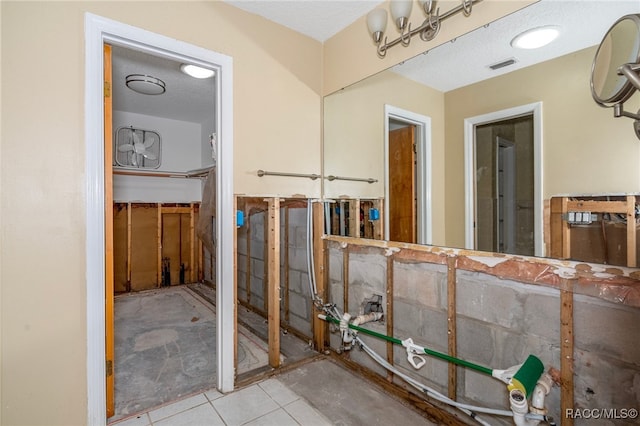 misc room with light tile patterned floors and a textured ceiling