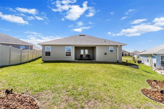 back of house featuring a shingled roof, fence, stucco siding, a lawn, and cooling unit