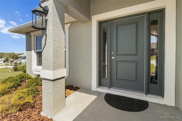 view of exterior entry featuring stucco siding