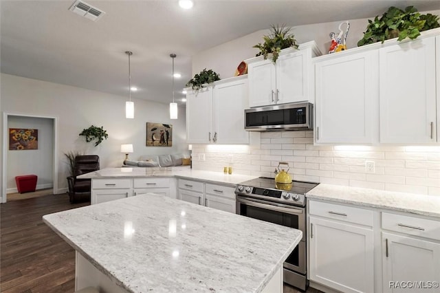 kitchen with stainless steel appliances, visible vents, a peninsula, and decorative backsplash