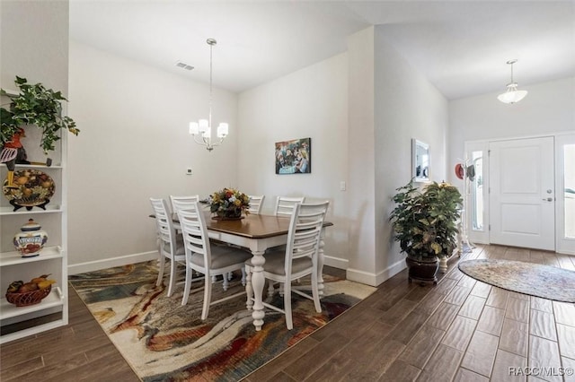 dining room with a chandelier, visible vents, baseboards, and wood tiled floor