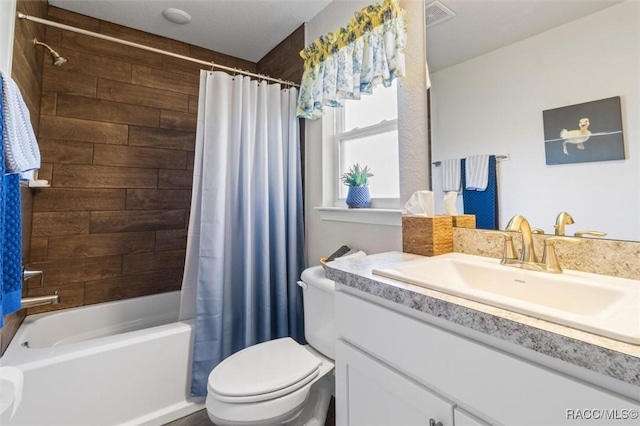 bathroom featuring visible vents, toilet, vanity, and shower / bath combination with curtain