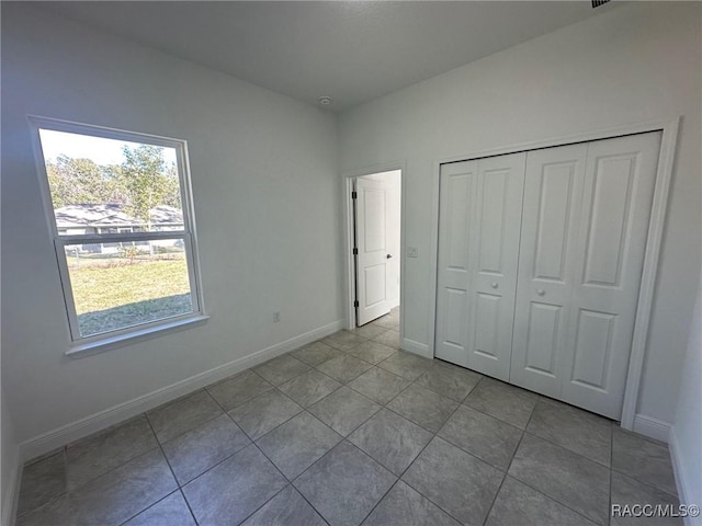 unfurnished bedroom with light tile patterned floors and a closet