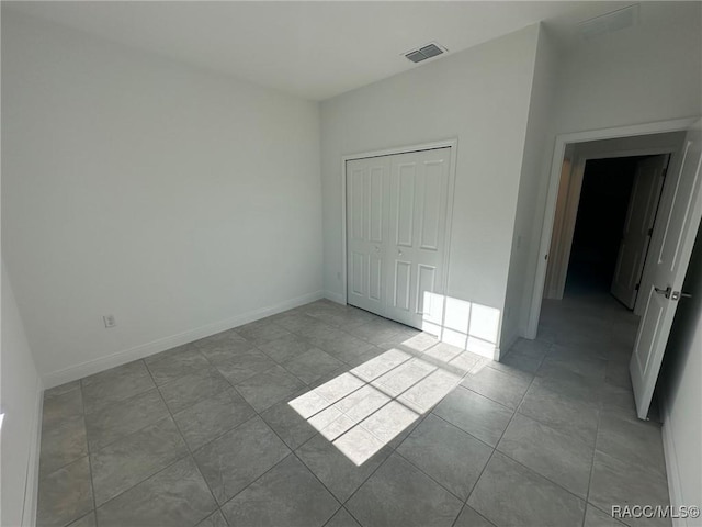 unfurnished bedroom with a closet and light tile patterned flooring