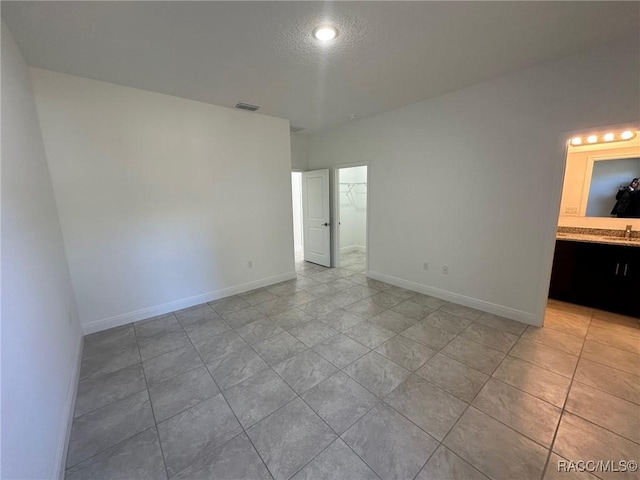 empty room with sink and a textured ceiling