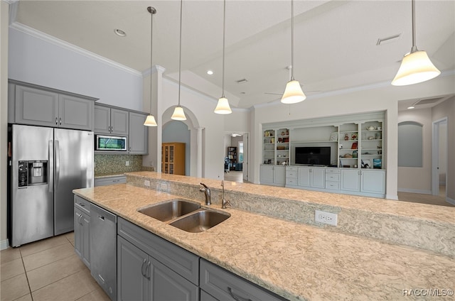 kitchen featuring gray cabinets, stainless steel appliances, decorative columns, and a sink