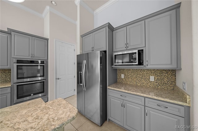 kitchen featuring crown molding, light tile patterned floors, appliances with stainless steel finishes, and gray cabinetry