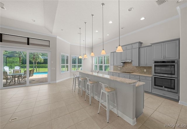 kitchen with backsplash, double oven, pendant lighting, gray cabinets, and light tile patterned flooring