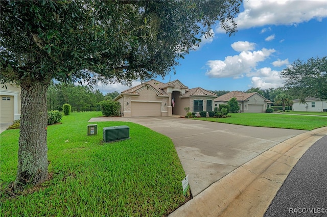 mediterranean / spanish-style house with stucco siding, an attached garage, concrete driveway, and a front yard