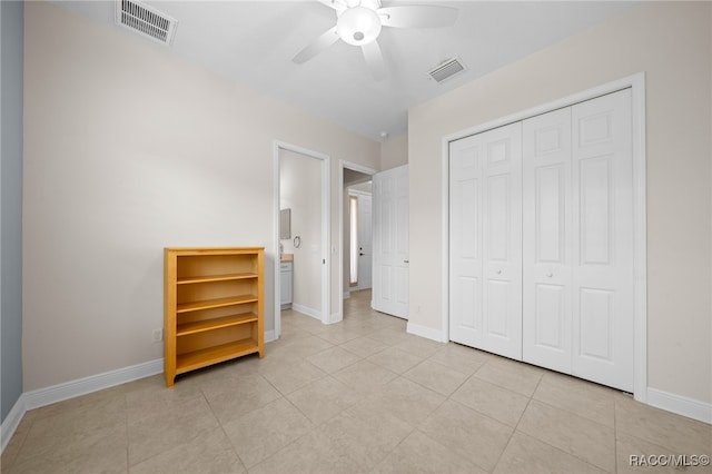 unfurnished bedroom with ceiling fan, a closet, and light tile patterned flooring