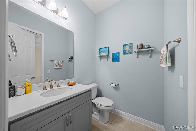 bathroom with baseboards, toilet, vanity, and tile patterned flooring