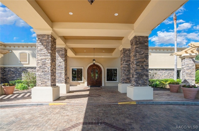 property entrance with stone siding and stucco siding