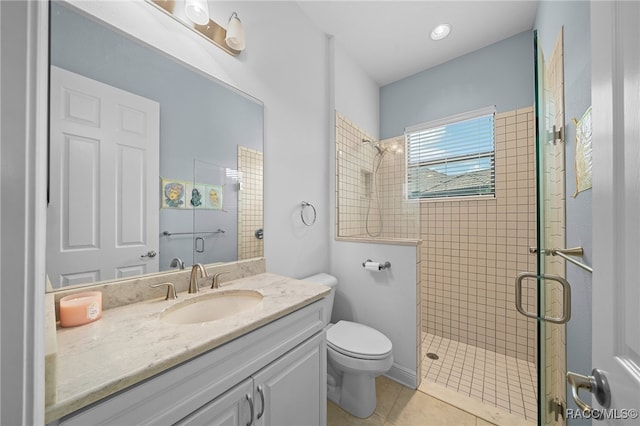 full bathroom with a tile shower, tile patterned flooring, toilet, and vanity