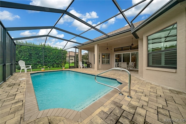 view of swimming pool with a lanai, ceiling fan, and a patio area