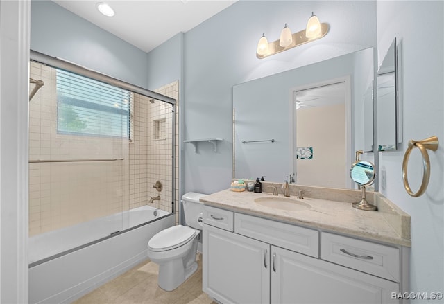 full bath featuring tile patterned floors, vanity, toilet, and shower / bath combination with glass door