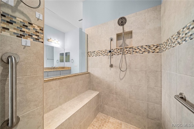 bathroom featuring vanity and tiled shower