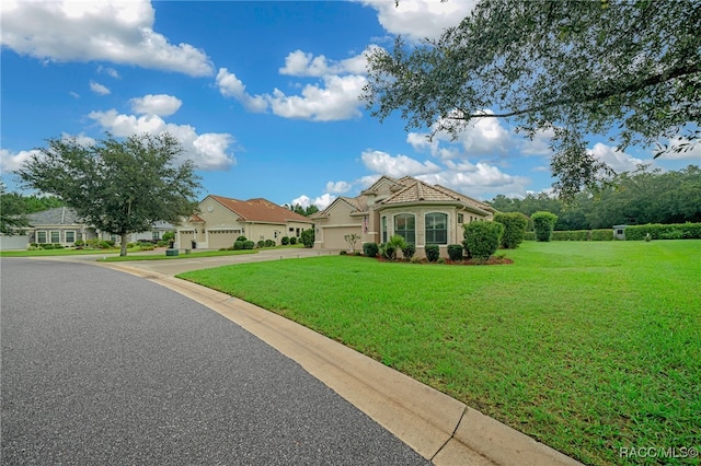 mediterranean / spanish-style house featuring a garage and a front lawn