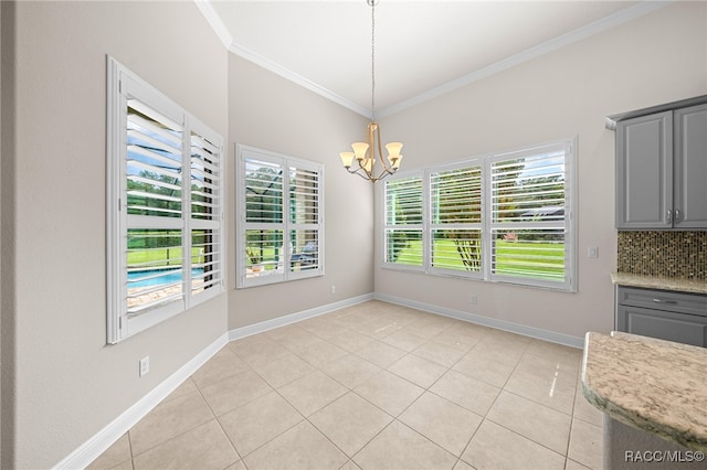 unfurnished dining area featuring light tile patterned floors, an inviting chandelier, a wealth of natural light, and ornamental molding