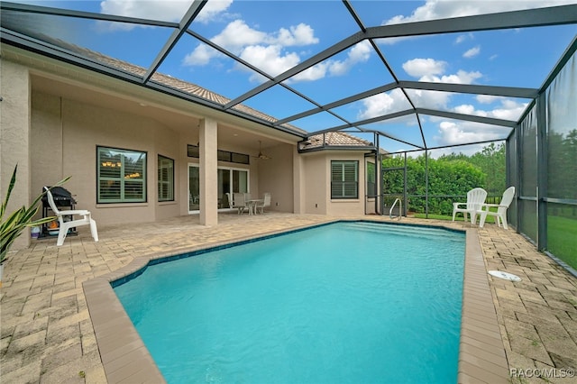 pool featuring a lanai, a patio area, and ceiling fan