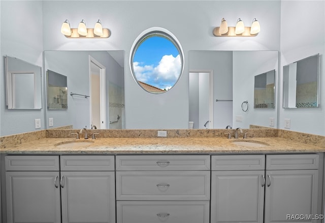 full bathroom featuring a sink, a shower, and double vanity