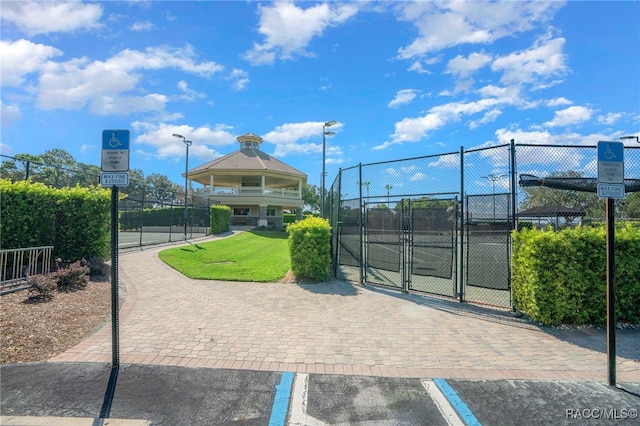 view of property's community featuring a gate, fence, and a lawn