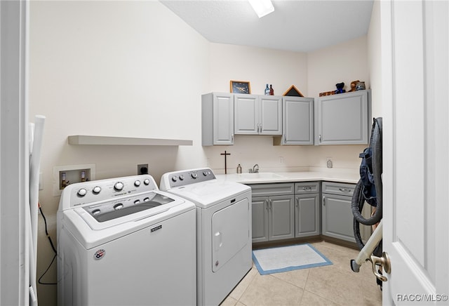 washroom featuring cabinets, washing machine and dryer, light tile patterned floors, and sink