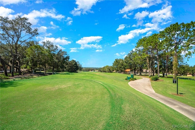 view of community featuring a lawn and view of golf course