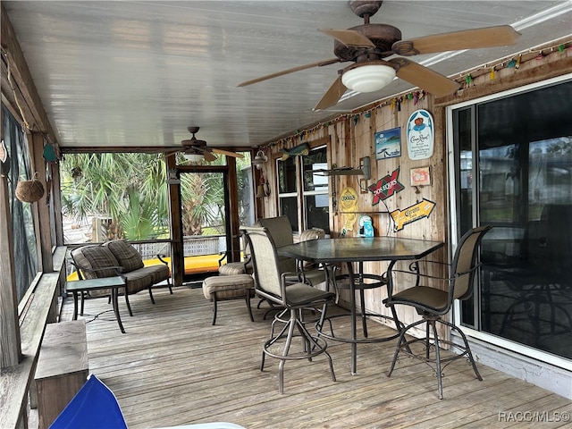 unfurnished sunroom featuring ceiling fan