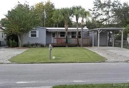 view of front facade featuring a carport and a front yard