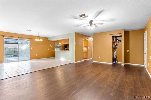 9780 W Tennessee Ln, Crystal River, FL 34428 - unfurnished living room featuring ceiling fan with notable chandelier and wood-type flooring