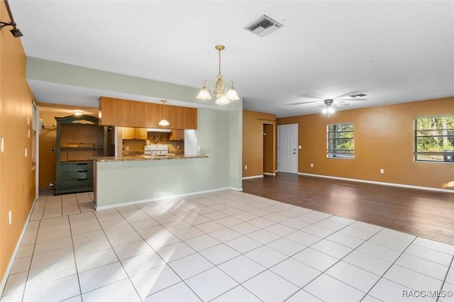 9780 W Tennessee Ln, Crystal River, FL 34428 - unfurnished living room with light tile patterned floors and ceiling fan with notable chandelier