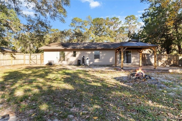 9780 W Tennessee Ln, Crystal River, FL 34428 - rear view of house with central AC unit, a fire pit, and a lawn