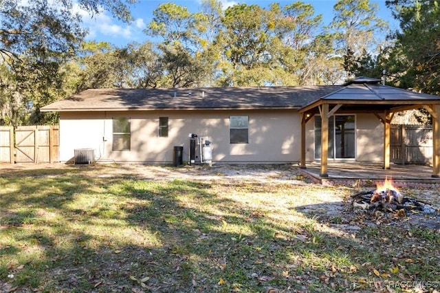 9780 W Tennessee Ln, Crystal River, FL 34428 - rear view of house with a gazebo, central AC unit, an outdoor fire pit, and a lawn