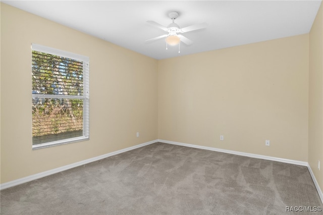 empty room with ceiling fan and light colored carpet