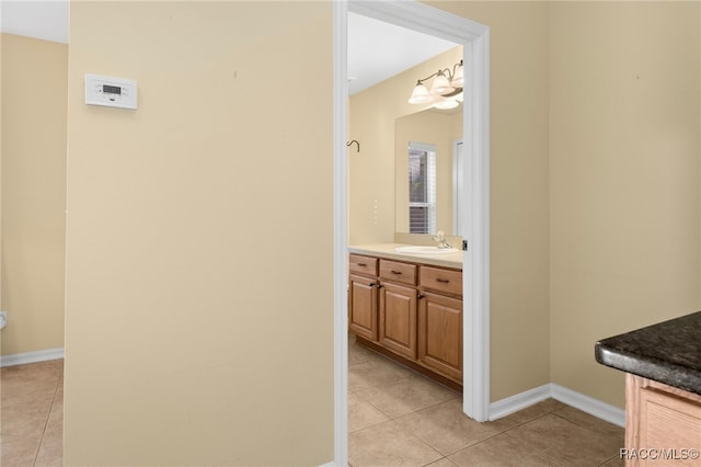 bathroom with tile patterned flooring, vanity, and a notable chandelier