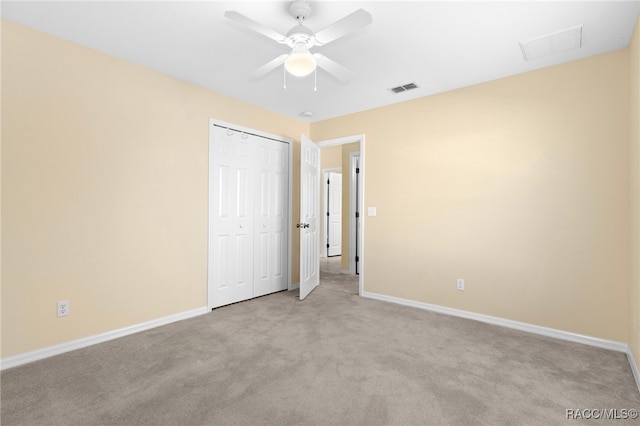 unfurnished bedroom with ceiling fan, a closet, and light colored carpet