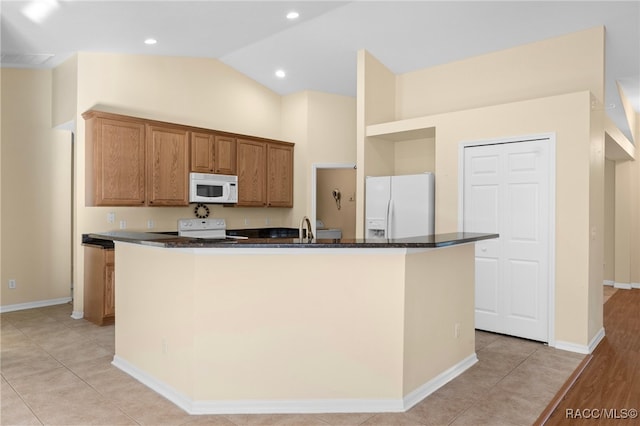 kitchen with lofted ceiling, white appliances, a kitchen island with sink, and light tile patterned floors