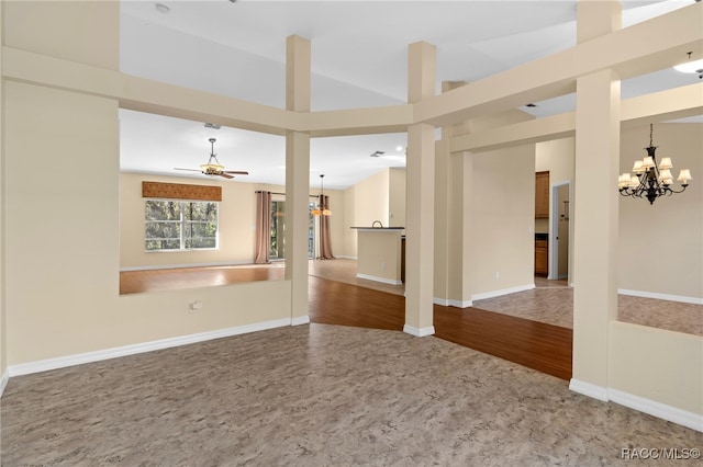 unfurnished room with lofted ceiling, wood-type flooring, and ceiling fan with notable chandelier