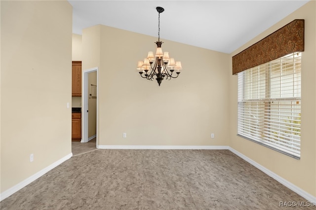 spare room featuring carpet, a notable chandelier, and vaulted ceiling