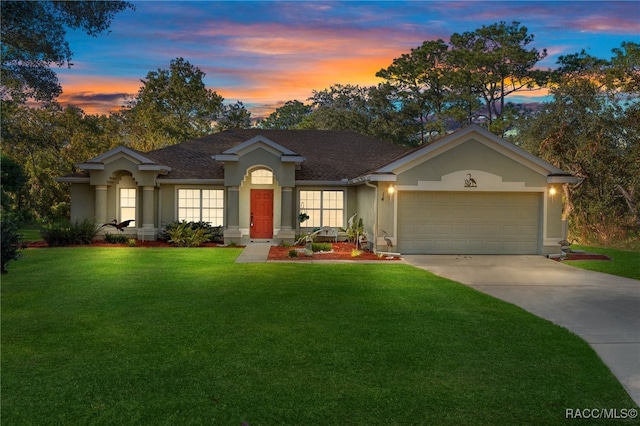 ranch-style house featuring a lawn and a garage