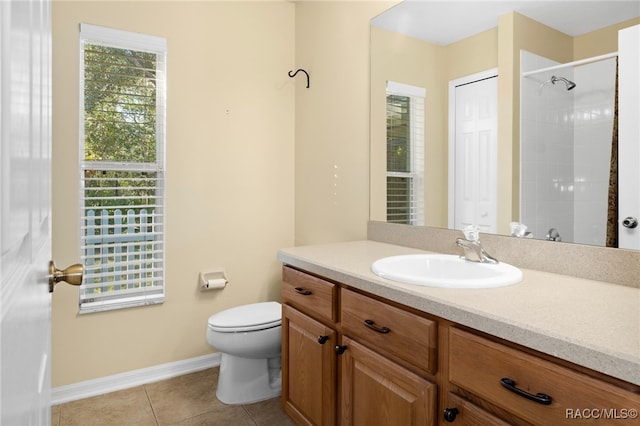 bathroom with tile patterned floors, a shower, plenty of natural light, and vanity