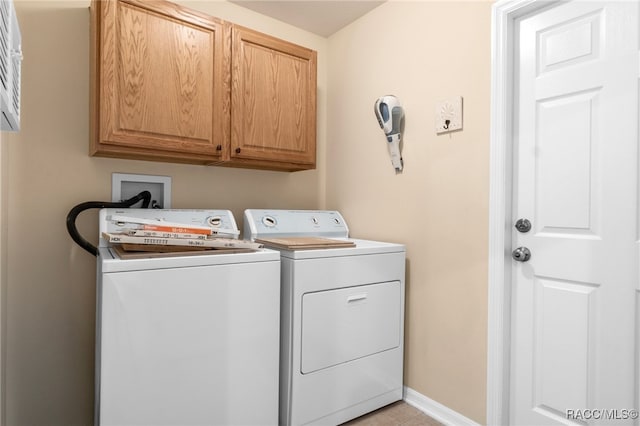 laundry room featuring light tile patterned flooring, cabinets, and separate washer and dryer