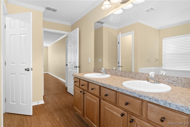 bathroom with wood-type flooring, vanity, ceiling fan, and ornamental molding