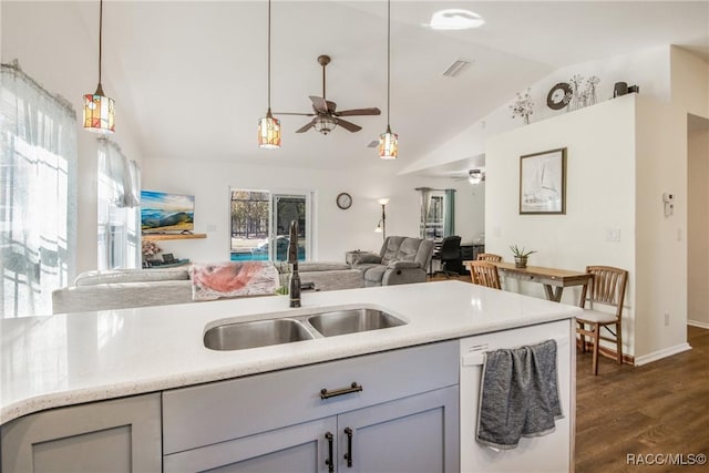 kitchen with sink, hanging light fixtures, dark wood-type flooring, white dishwasher, and lofted ceiling