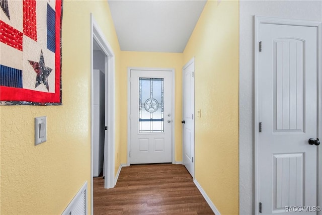 doorway with dark wood-type flooring and vaulted ceiling